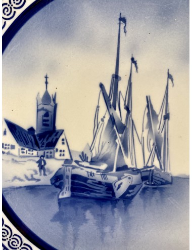 Wandbord - groot - ongemerkt - met ophangoog - in het midden een blauw spuitdecor van oude schepen, een kerkje en molens